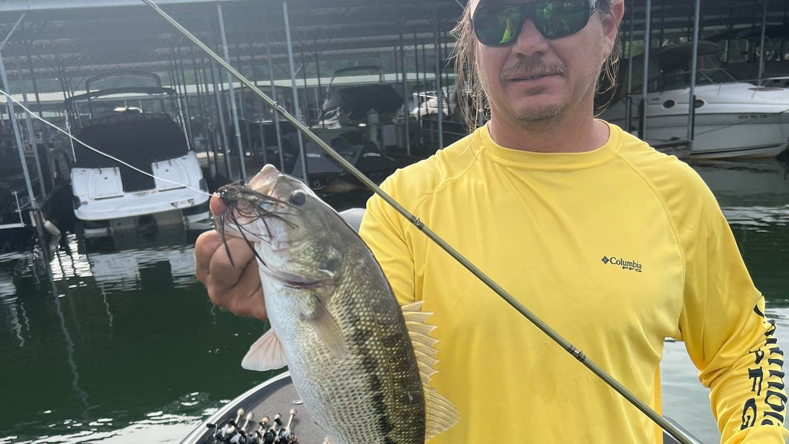 Angler holding bass with jig in mouth